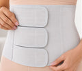 Close-up of a woman adjusting the middle strap of the grey SUPEAK Postpartum Belly Band, showcasing its three adjustable compression panels wrapped around the waist.